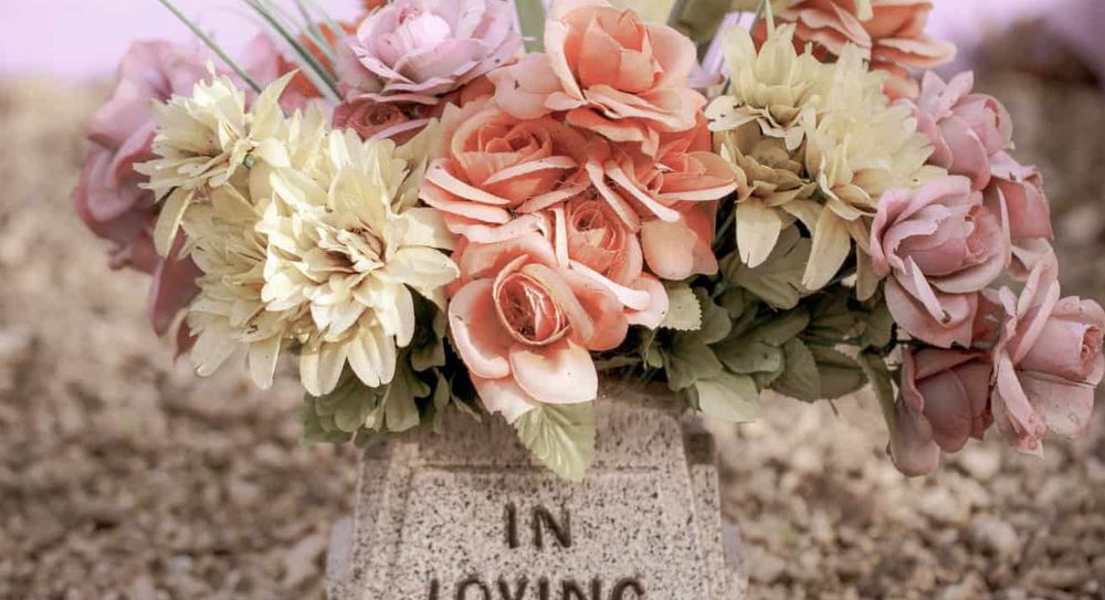 A stone vase memorial that reads "in loving memory".