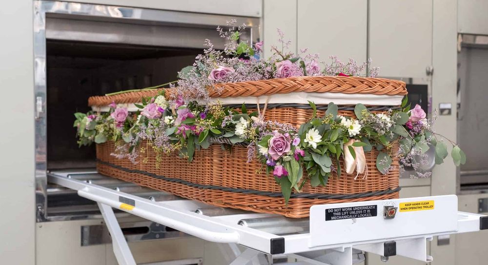A wicker coffin about to be placed inside a cremator.