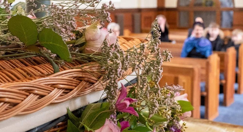 A wicker coffin at a funeral service.