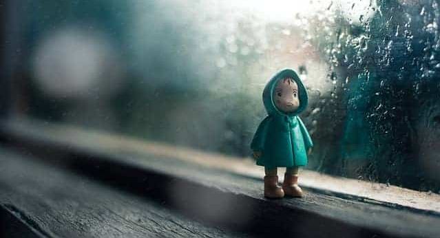 A child's toy in front of a rainy window.
