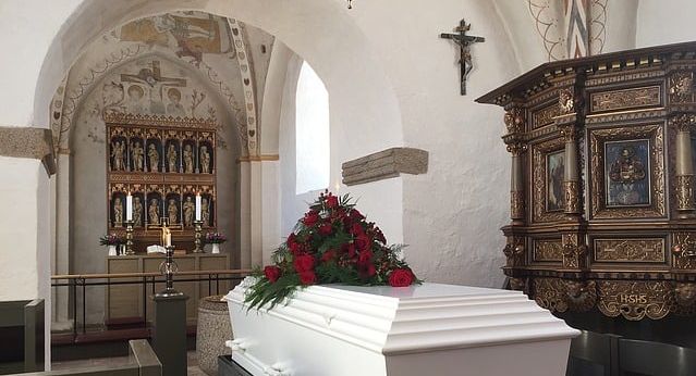 A white coffin in a church.