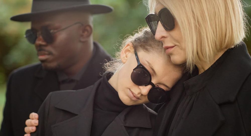 Two mourners at a funeral.