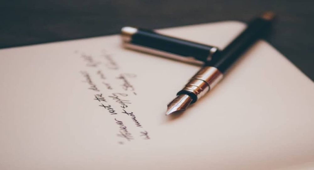 A handwritten document with a fountain pen.