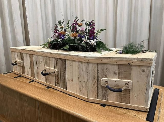 Soft wooden coffin with floral spray   Ecological coffins
