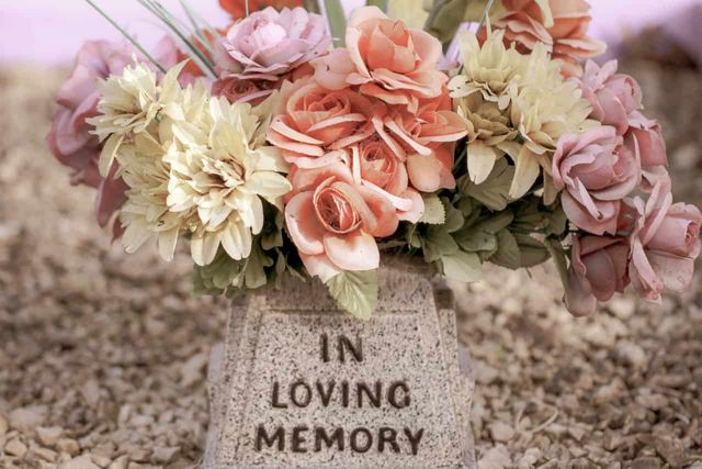 A stone vase memorial that reads "in loving memory".