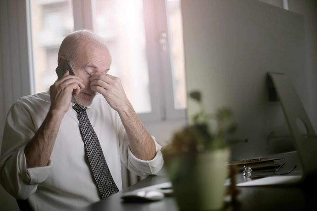 A man on the phone looking stressed.
