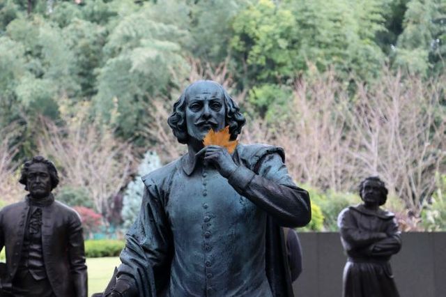 Bronze statue of William Shakespeare holding an autumn leaf
