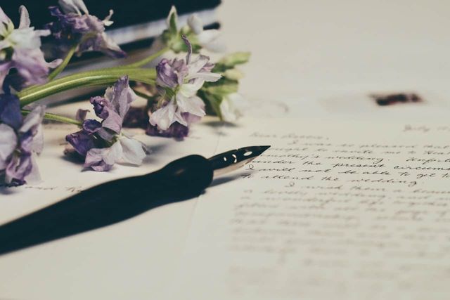 Flowers and a fountain pen lying on a piece of paper.
