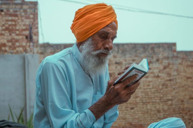 Sikh man in a turban reading a prayer book
