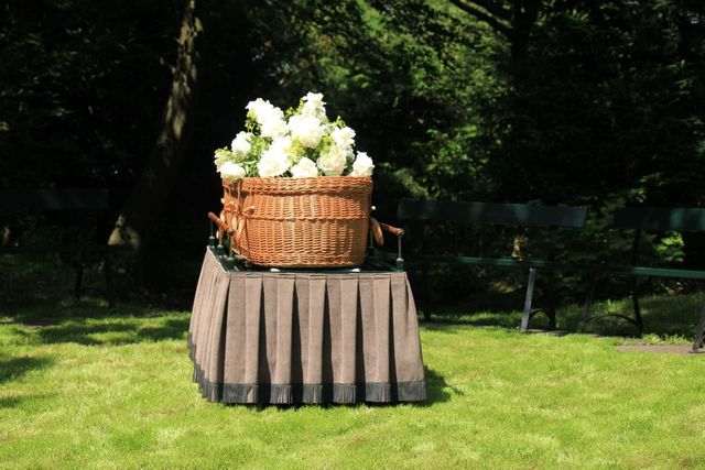 A wicker coffin sitting on top of a catafalque.