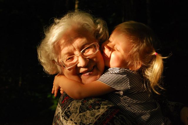Grandmother embraced by child. 