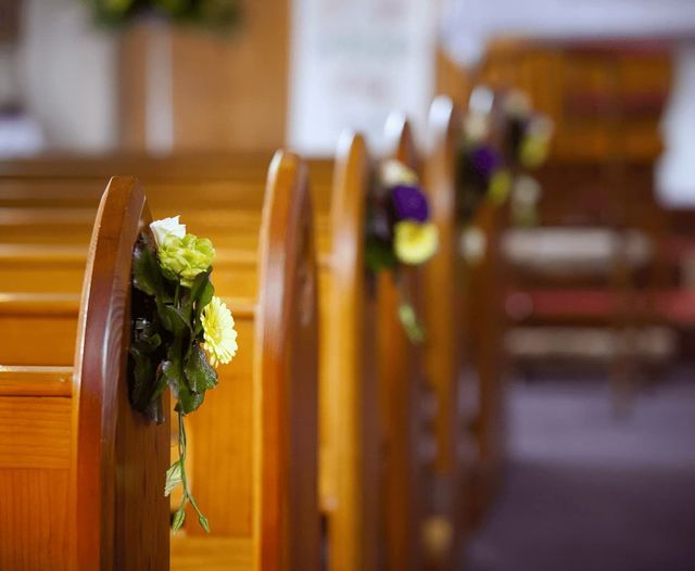 White and yellow flowers on seats at a church funeral